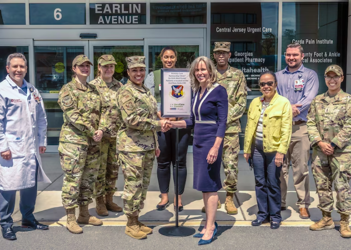 group of people standing in front of a building with sign