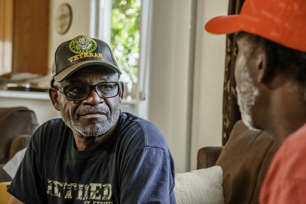 Military Veterans in Their Seventies Having a Casual Conversation in a Residential Living Room