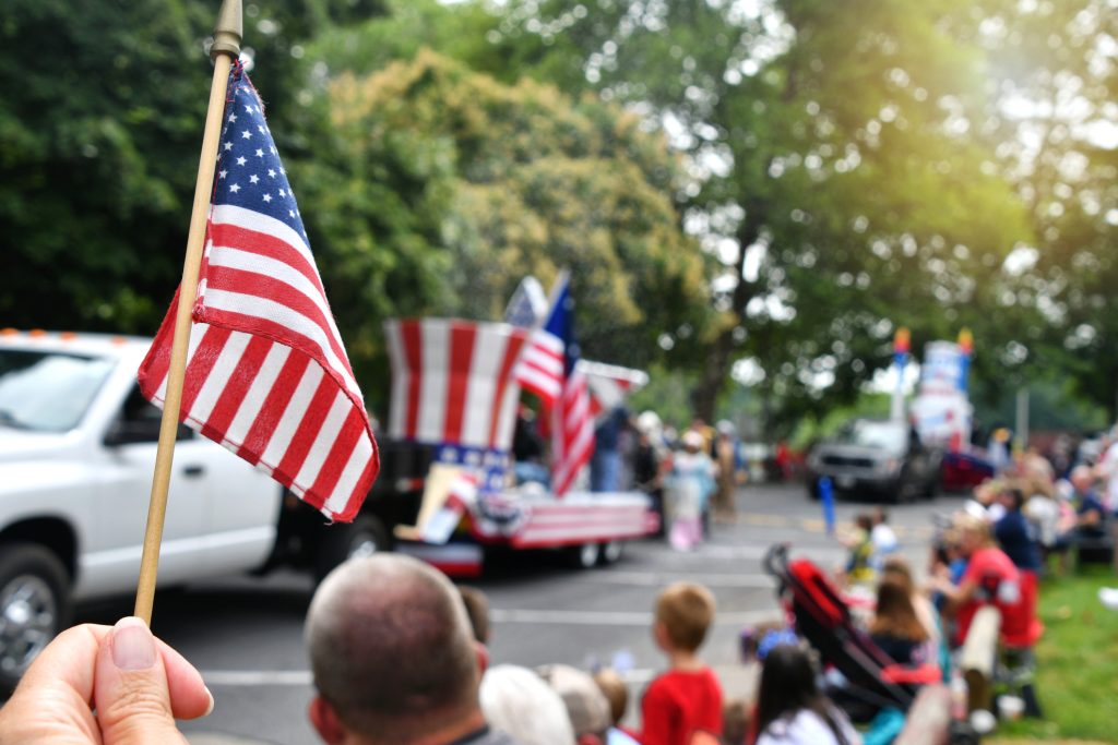 Flag at with Independence Day parade in background