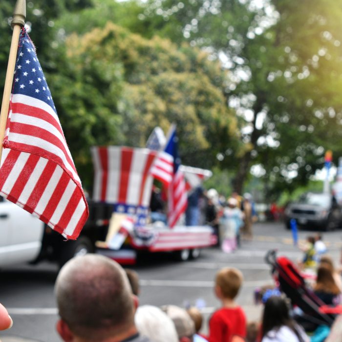 Flag at with Independence Day parade in background